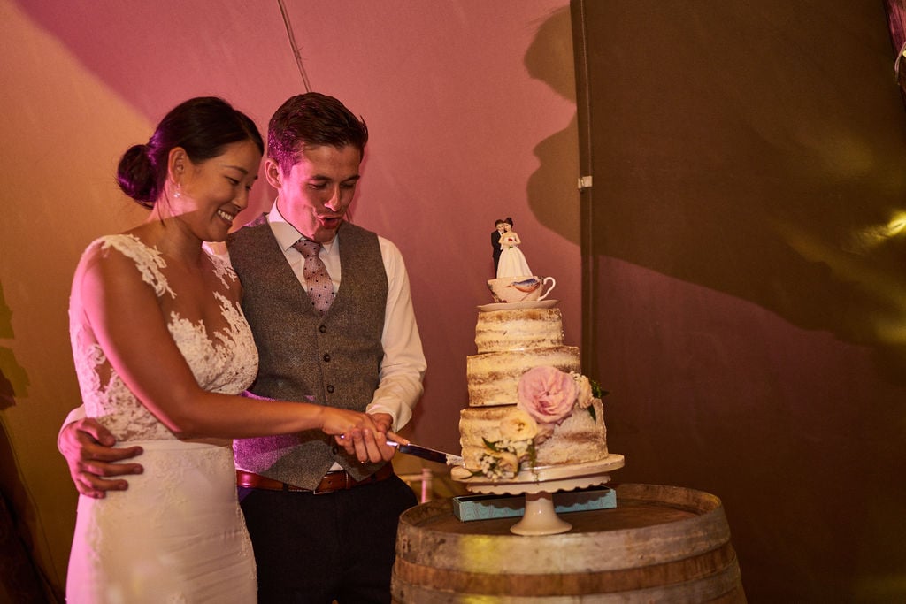 PapaKåta couple Lucy & Chris' Teepee Wedding in Terrington North Yorkshire captured by Chris Morse Photography- Cutting the cake 