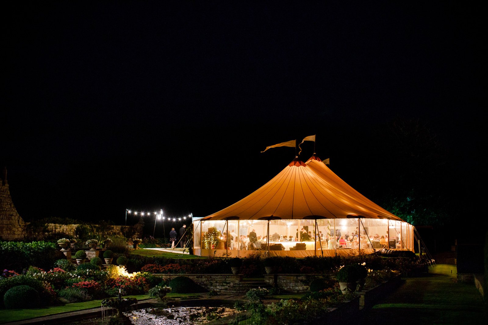 Emily & Ed's PapaKåta Sperry Tent wedding at Buckhurst Park captured by Tony Hart Photography: Sperry Tent Exterior at night