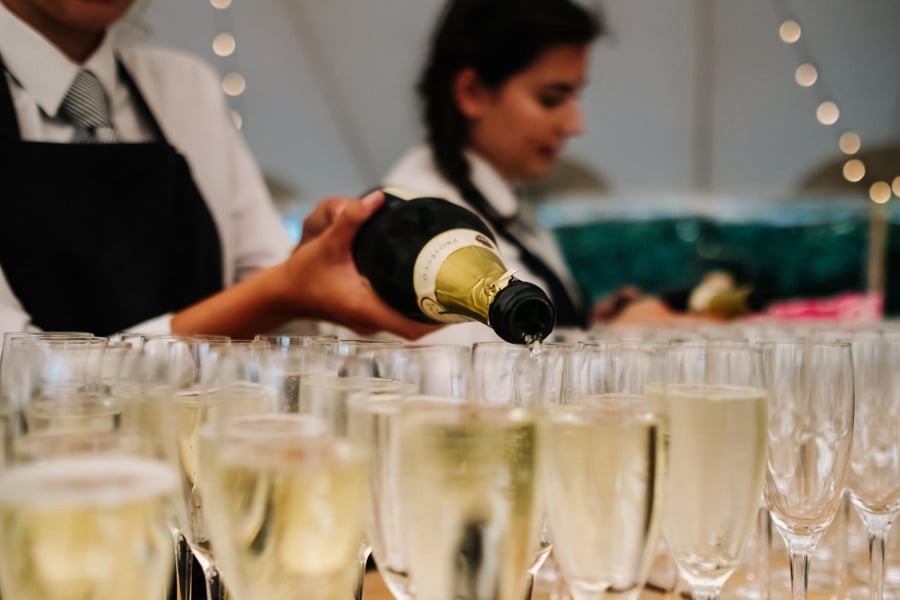 Natalie & Jack's PapaKåta Sperry Tent wedding at Lingholm Estate, Keswick, Lake District captured by Kristian Leven Photography: Pouring the Champagne