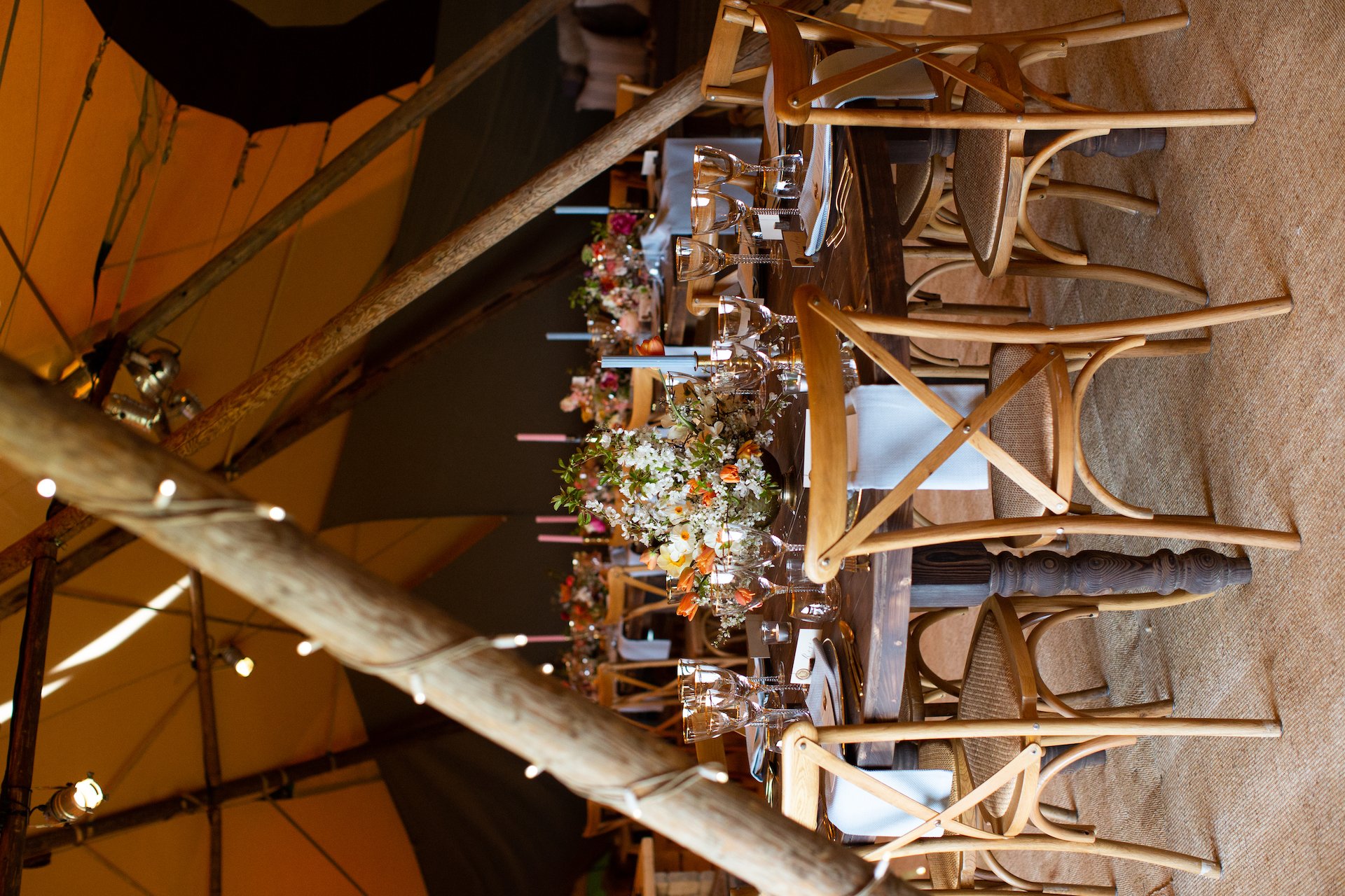 PapaKåta Spring Open Weekend Teepee captured by Lucy Davenport Photography: Round Farmhouse Table with Cross Back Chairs, Floral Centrepiece by Aelisabet Flowers