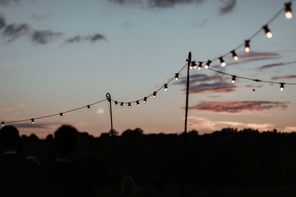Georgie & Will Stunning PapaKåta Tipi Tent Wedding near Henley-on-Thames, Oxfordshire. Captured beautifully by Olivia & Dan Photography; Festoon Lights at Sunset